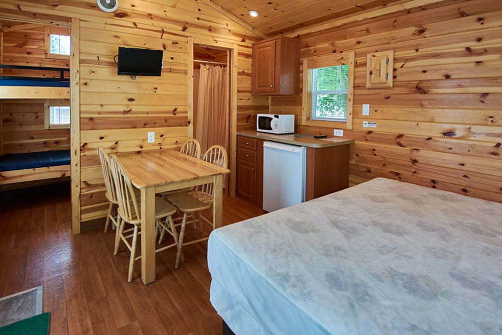 inside of cabin with kitchen area and bed